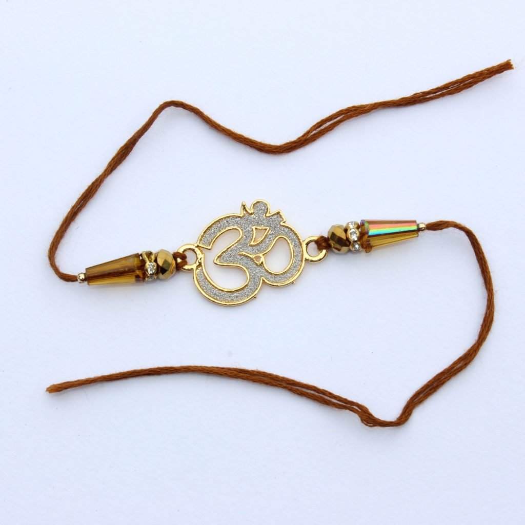 Rakhi thread with a gold Om pendant on a white background